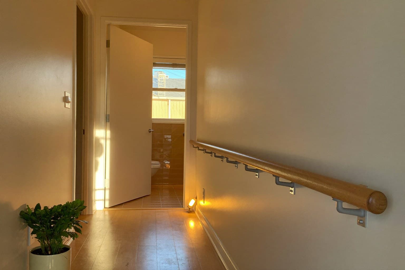 Clear, well-lit hallway with a handrail, an example of fall prevention for seniors at home