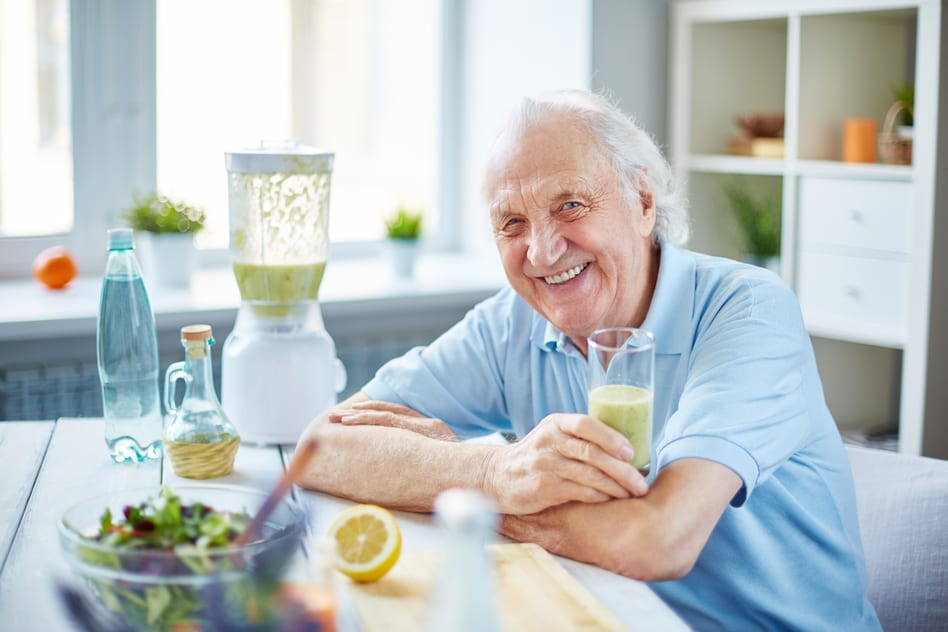 Senior man with a glass of matcha smoothie