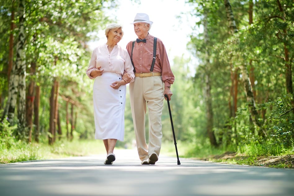 Blissful senior couple walking on the road on a bright morning