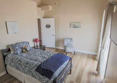 Room with 1 bed and a chair for a senior resident